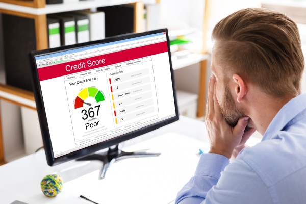 A landlord sitting at his desk reviewing a potential tenant's credit score. The score is 367, which is a poor rating.