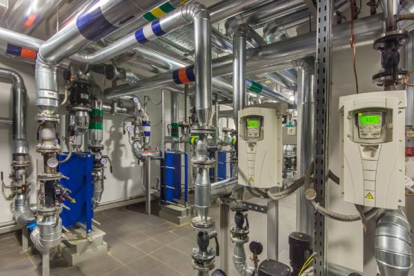 A heating system in a commercial boiler room consisting of pipes, pumps, valves, and other components.