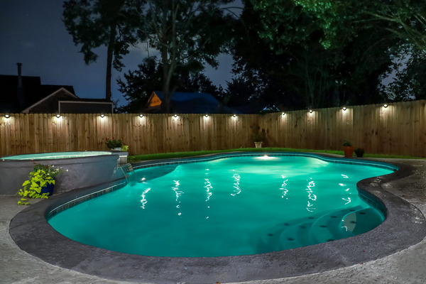 lighting pool safety style A newly built backyard swimming pool and jacuzzi hot tub at night. There are lights along the wooden fence.