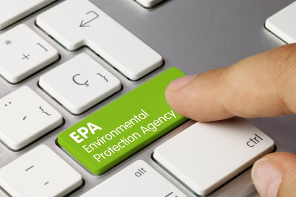 A finger at close range presses a green key on a keyboard that reads, "EPA Environmental Protection Agency."