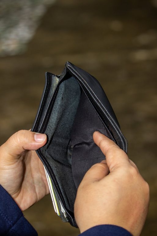 money tariffs person holding a black wallet