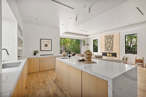 A contemporary style luxury home showcasing its open layout and kitchen equipped with a marble countertop.