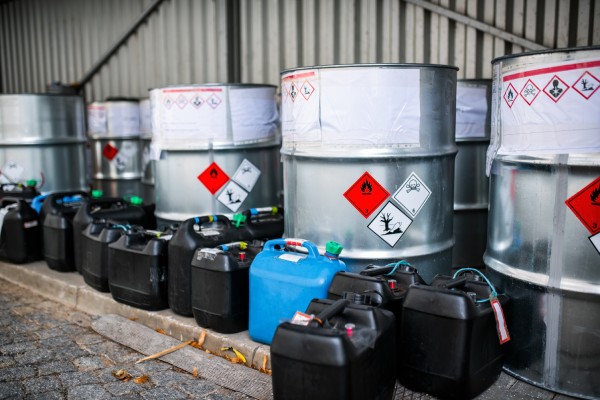 A close-up of multiple storage bins of toxic waste and chemicals on the factory premises of a chemical plant.